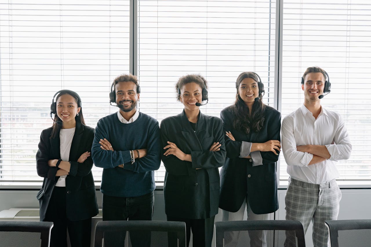 services-03 Diverse group of smiling customer service agents wearing headsets in modern office.